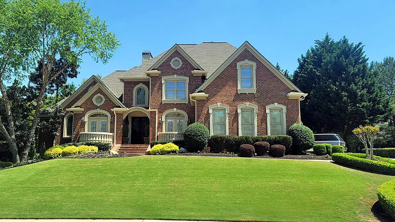 A wide curb view of an irrigated and planted property