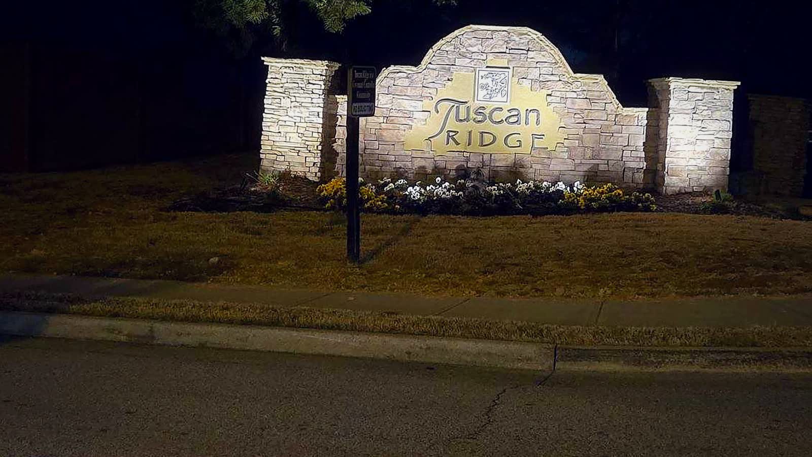 A lit stone subdivision monument at night